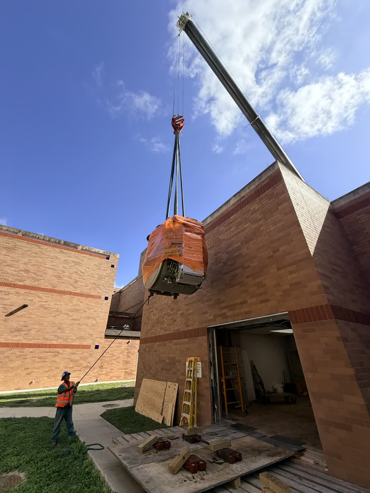 MRI machine brought through a wall and lowered onto the first story