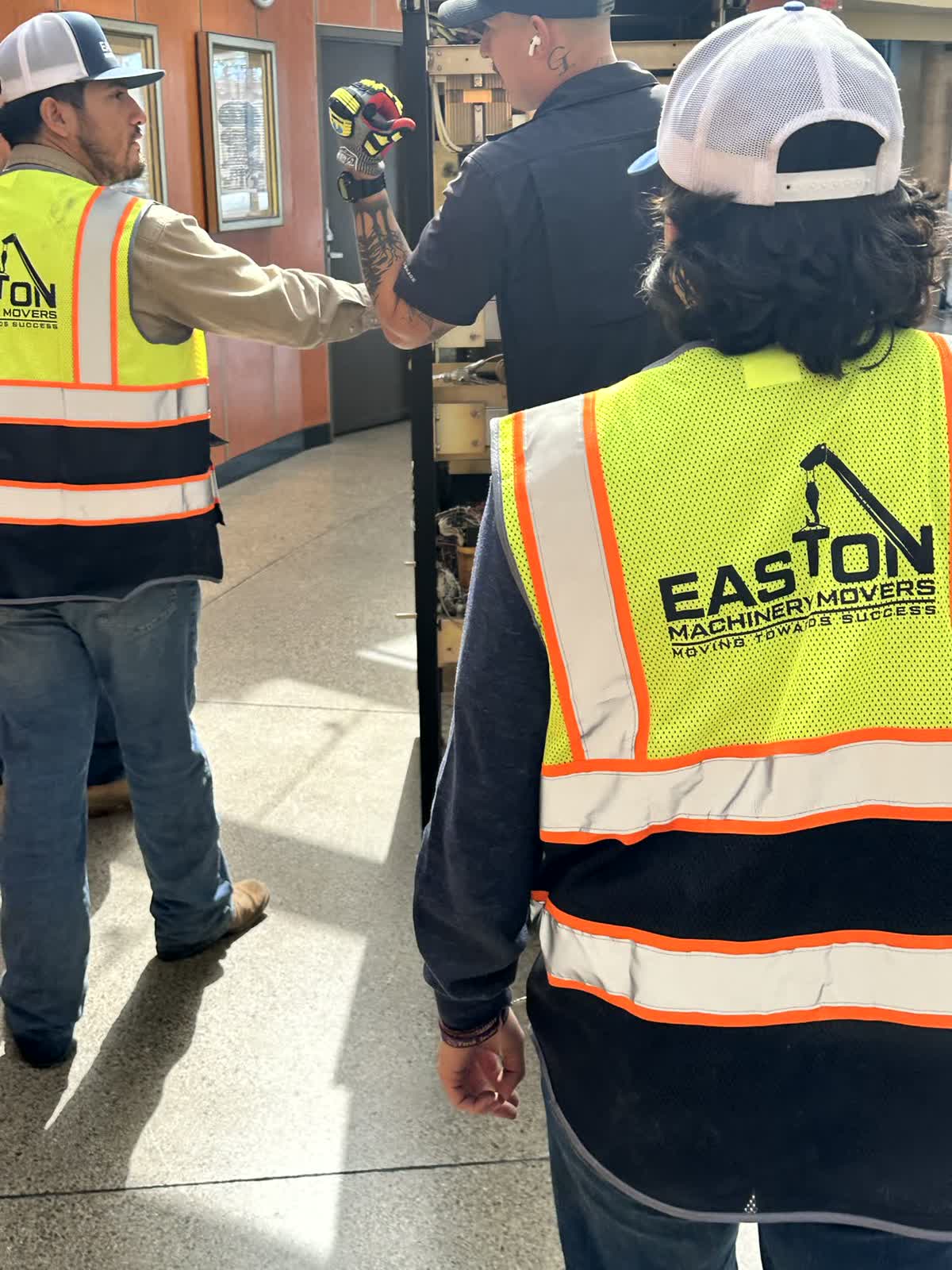 Two Easton Machinery Movers crew directing a lift on site in San Antonio